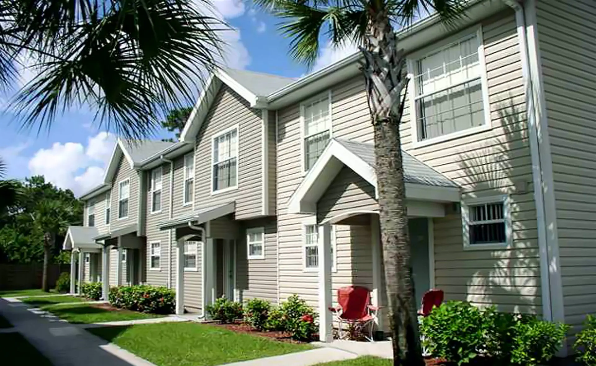 Townhomes with palm trees and landscaped walkways