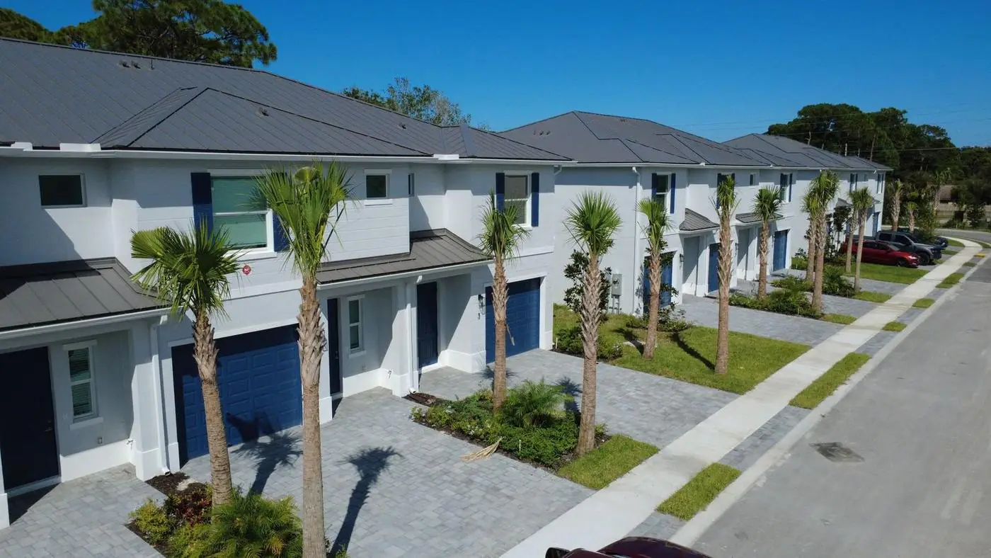 Estancia townhomes along a palm-lined street